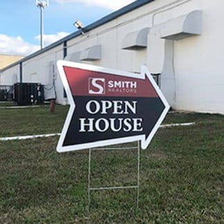 Printed coroplast yard signs staked in the ground outside a Houston business