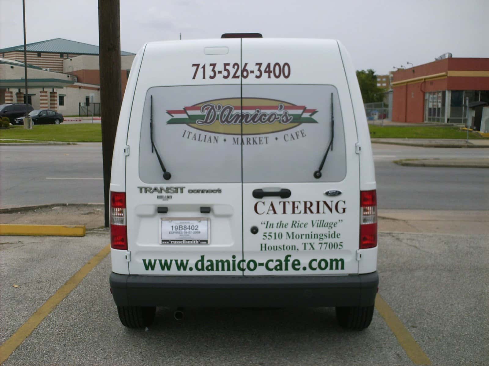A Ford Transit Connect with custom vehicle graphics for a Houston business